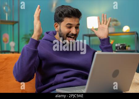 Oh my God Wow. Surprised indian man using laptop computer, receive good news message, shocked by sudden victory, celebrate lottery jackpot win purchases online shopping at home. Lifestyle technologies Stock Photo