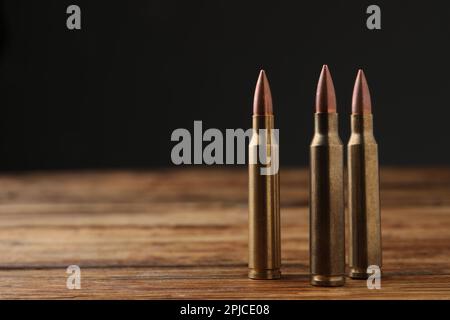 Three bullets on wooden table. Space for text Stock Photo