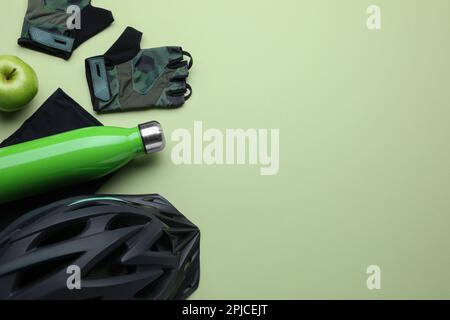 Flat lay composition with different cycling accessories and clothes on light background, space for text Stock Photo