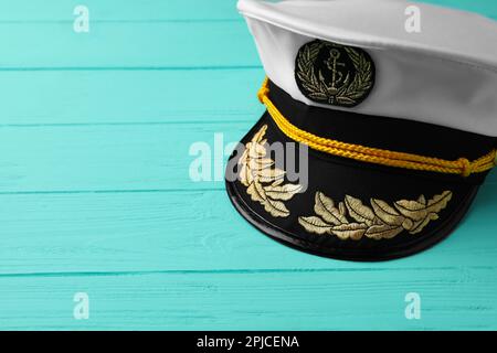 Peaked cap with accessories on turquoise wooden background, space for text Stock Photo