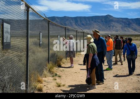 Tourists look at photographs hung on a fence from the first atomic bomb test at the Trinity Site on April 1, 2023 at the White Sands Missile Range, New Mexico. The bomb was tested at 5:29:45 a.m. Mountain War Time on July 16, 1945 at the Trinity Site which is open to the public twice a year - the first Saturday in April and third Saturday in October. (Photo by Sam Wasson/Sipa USA) Credit: Sipa USA/Ģ����ý Live News Stock Photo
