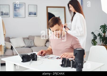 Two photographers in casual clothes is working indoors at daytime Stock Photo