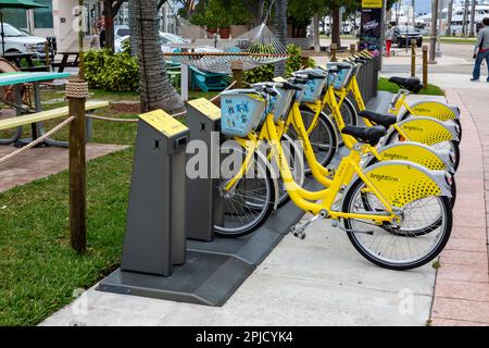 These yellow Brightline Bike rental bicycles are parked on Clematis Street in downtown West Palm Beach, Florida, USA. Stock Photo