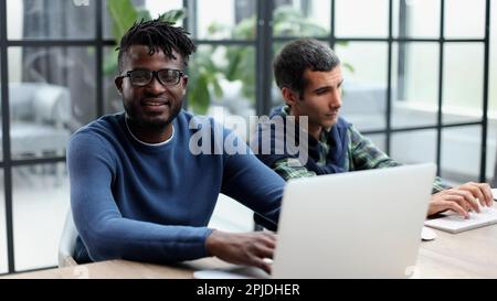 Two men colleagues sharing creative ideas, using digital tablet Stock Photo