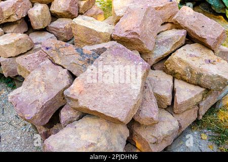A pile of worked old sandstones on a construction site for the restoration of an old wall Stock Photo