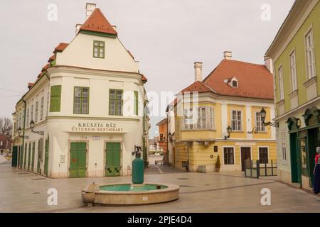 Gyor, Hungary - March 31 2023 : Cobblestone street and square with old houses in downtown of Gyor, Hungary. Gyor has a beautiful baroque old city. Stock Photo