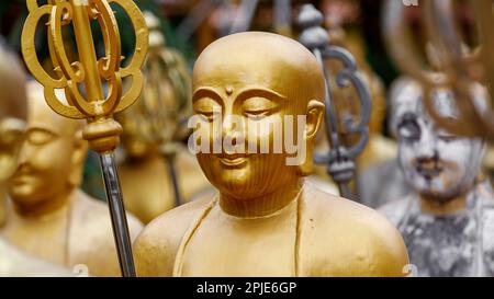 Buddhist statue of gold monks. Kṣitigarbha monk statues holding khakkhara or tiger pewter staffs. Mahayana Buddhism. Guardians of cemeteries. Stock Photo