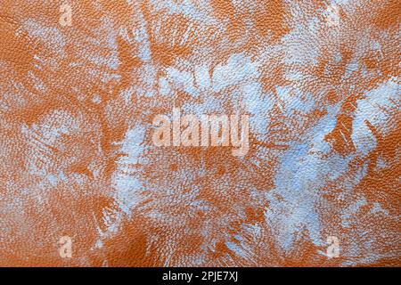 Brush stamp strokes with blue paint on red brown leather texture, close up Stock Photo