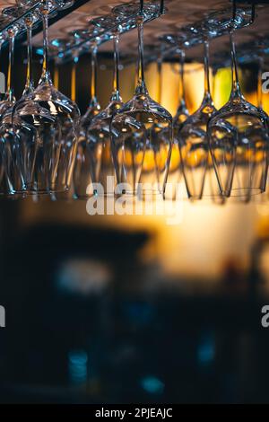 set of shiny dry wineglasses over bar counter in nightclub Stock Photo
