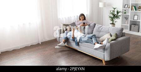 High angle view of multiracial couple relaxing on couch Stock Photo