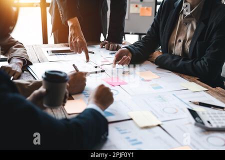 Diverse businesspeople cooperate work together discussing company financial statistics, multiracial colleagues employees collaborate brainstorm with Stock Photo