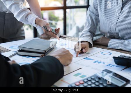Diverse businesspeople cooperate work together discussing company financial statistics, multiracial colleagues employees collaborate brainstorm with Stock Photo