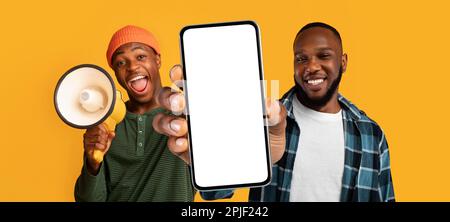 Two Black Males Advertising Mobile Offer, Showing Blank Smartphone And Using Loudspeaker Stock Photo