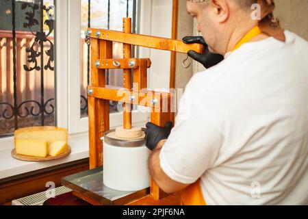 Cheese maker showing cheese wheel at the cheese storage Stock Photo - Alamy