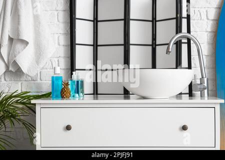 Chest of drawers with sink, accessories and mirror in bathroom Stock Photo