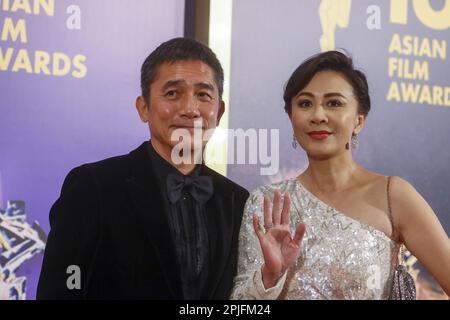 Actor Tony Leung Chin-wai (left) and his wife Carina Lau Ka-ling (right) pose on the red carpet at the 16th Asian Film Awards at Hong Kong Palace Museum, in Hong Kong.   12MAR23.   SCMP / Dickson Lee Stock Photo