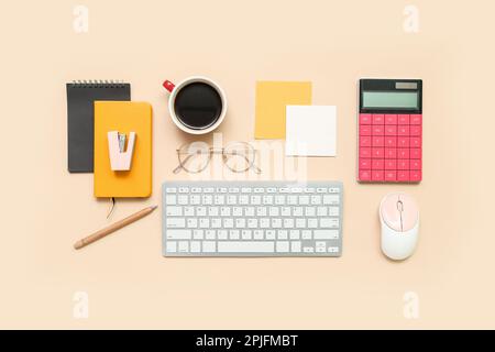 Composition with keyboard, coffee, calculator and notepad on beige background Stock Photo