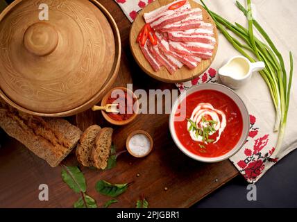 Traditional Ukrainian towel along with garlic, bread and salt. Top view of a wooden tray on a black background on which lies Ukrainian food with spice Stock Photo
