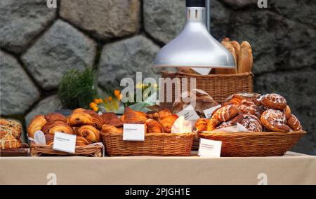 Stand with fresh sweet and savoury pastries on display at the Náplavka Farmers' Market in winter at the beginning of the new season, selective focus, Stock Photo