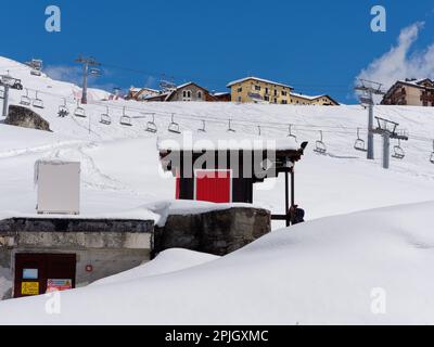 Ski Lift surrounded by snow and buildings in the ski resort of Breuil-Cervinia in the Aosta Valley Italy Stock Photo