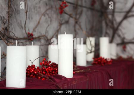 scenery from white candles and berries on a red background Stock Photo