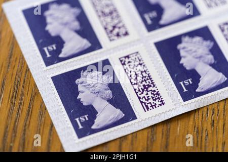 An open book of self adhesive indigo coloured first class stamps showing Queen Elizabeth II and QR codes. March 2023, UK. Stock Photo