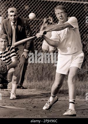 Carter at bat during a softball game at Plains High School. The umpire is consumer advocate and future five-time presidential candidate Ralph Nader. The catcher is James Wooten of the New York Times. Stock Photo