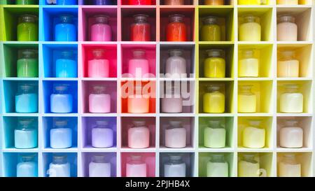 Jars with multi-colored repair paints on the shelves, multicolor abstract background Stock Photo