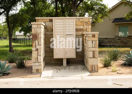 Georgetown, Texas USA - neighborhood street-side cluster mailbox inside 3 sided stone enclosure Stock Photo