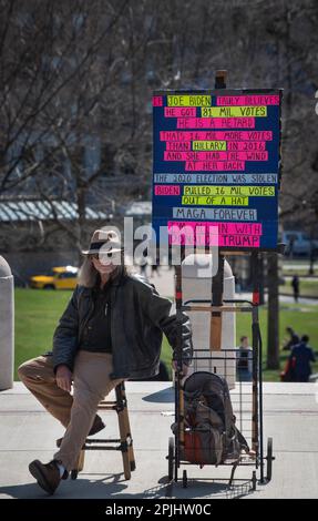 Trump Indictment: 31 March 2023, Boston, MA, USA: A single Trump supporter, Bob, 69, sat across Beacon Street in central Boston as small group of supporters of the prosecution of former U.S. President Donald Trump gathered on the steps of the Massachusetts State House in central Boston at noon on Friday. Stock Photo