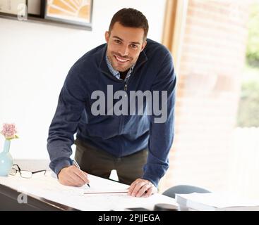 Architecture is his art. Portrait of a young man drawing up plans at his desk. Stock Photo