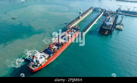 Tug boat Draging cargo container ship to dry dock concept maintenance service working in the sea. Insurance and Maintenance Cargo Ship concept. Freigh Stock Photo