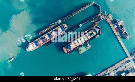 Tug boat Draging cargo container ship to dry dock concept maintenance service working in the sea. Insurance and Maintenance Cargo Ship concept. Freigh Stock Photo