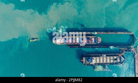 Tug boat Draging cargo container ship to dry dock concept maintenance service working in the sea. Insurance and Maintenance Cargo Ship concept. Freigh Stock Photo