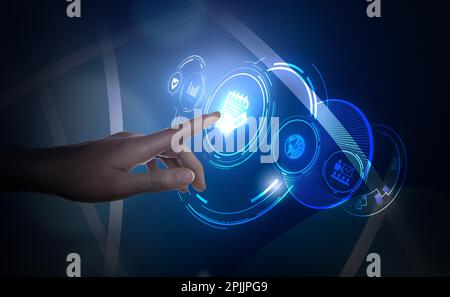Woman pointing at virtual screen with icon of computer file on dark background, closeup Stock Photo