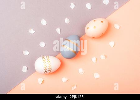 Colorful Easter eggs on pink and gray background. Top view, flat lay. Stock Photo