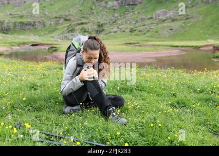 Hiker complaining suffering knee ache after accident in the mountain Stock Photo