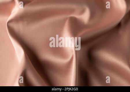 Close up of plain beige satin fabric with folds, copy space Stock Photo