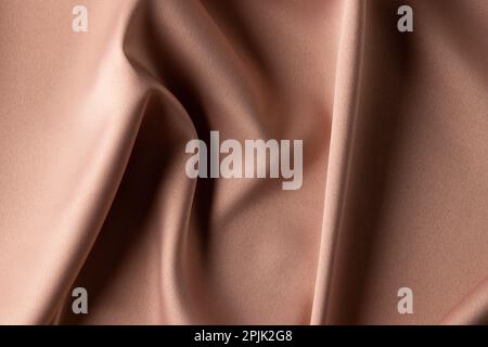 Close up of plain beige satin fabric with folds, copy space Stock Photo