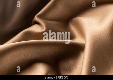 Close up of plain beige satin fabric with folds, copy space Stock Photo