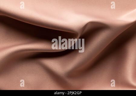 Close up of plain beige satin fabric with folds, copy space Stock Photo