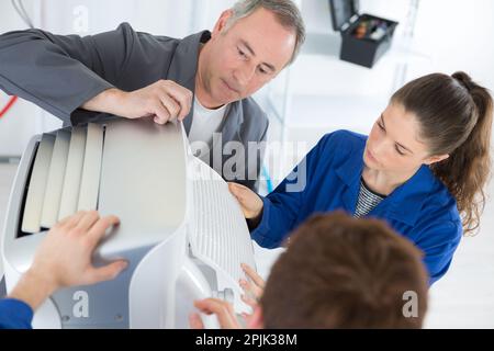 the apprentices and technician inspecting aircondition Stock Photo