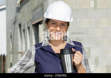 female construction worker having a coffee break Stock Photo