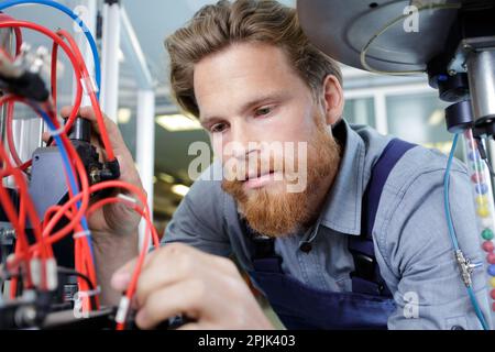 young mechanical engineering operates a machine Stock Photo