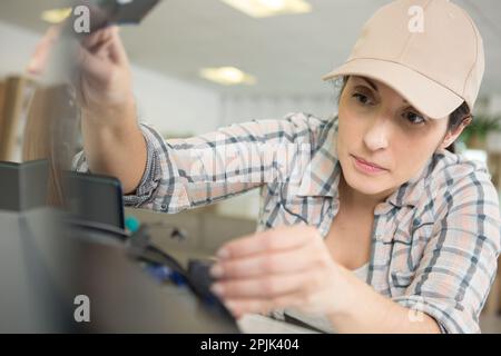 mature woman fixing a printer Stock Photo