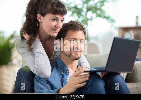 happy millennial couple sit relax on couch in living room Stock Photo