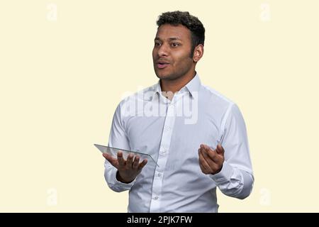 Young brown businessman with glass tablet pc mockup. Manager presents a new project. Isolated on white. Stock Photo