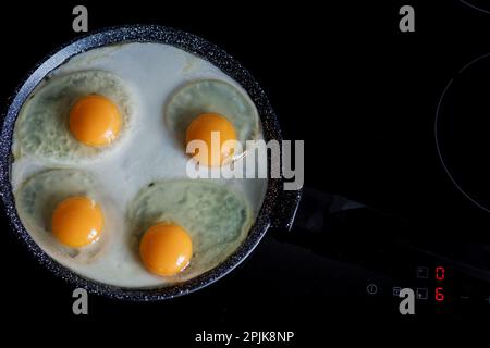 4 four fried egg yolks in frying pan Stock Photo - Alamy