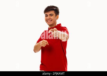 Portrait of young man pointing towards camera against white background Stock Photo