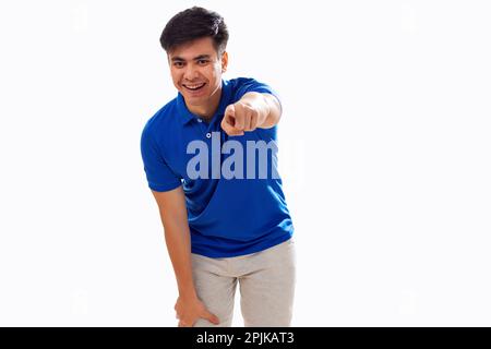 Portrait of young man pointing towards camera against white background Stock Photo
